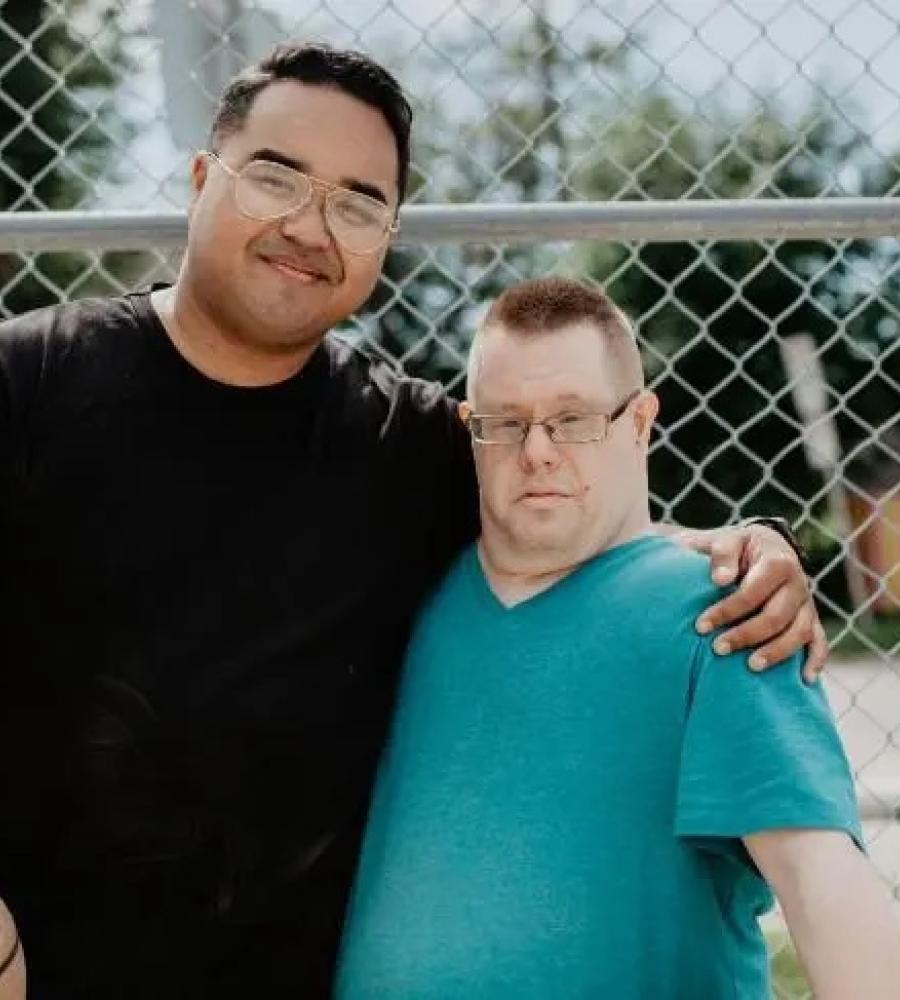 DSP and the person he supports are smiling at the camera holding a basketball.